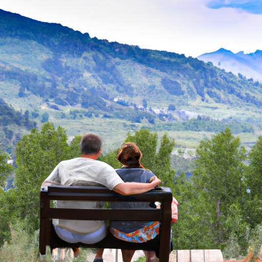 Một cặp đôi ngồi trên ghế đá, nắm tay nhau, phía sau là khung cảnh núi non hùng vĩ.