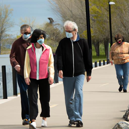Một nhóm người già đeo khẩu trang khi đi bộ cùng nhau trên con đường thành thị được lát bê tông ven sông.