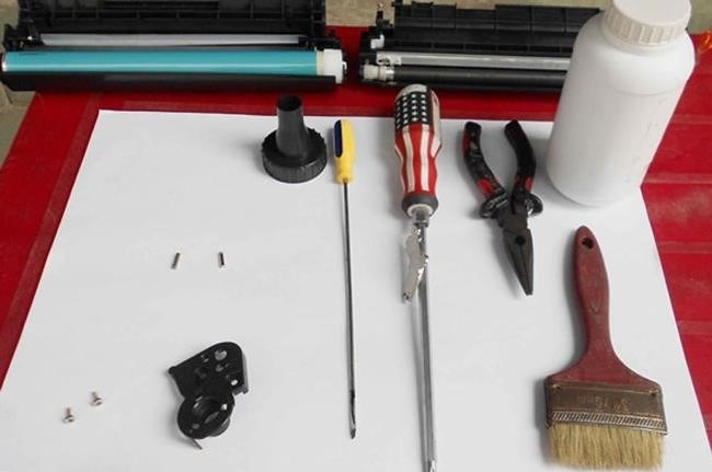 Để tháo hộp mực máy in Canon 2900, bạn cần chuẩn bị các dụng cụ như: cây chổi lau, giấy lau, dao cắt nhỏ, băng keo và găng tay để tránh bị bẩn mực khi tháo hộp.